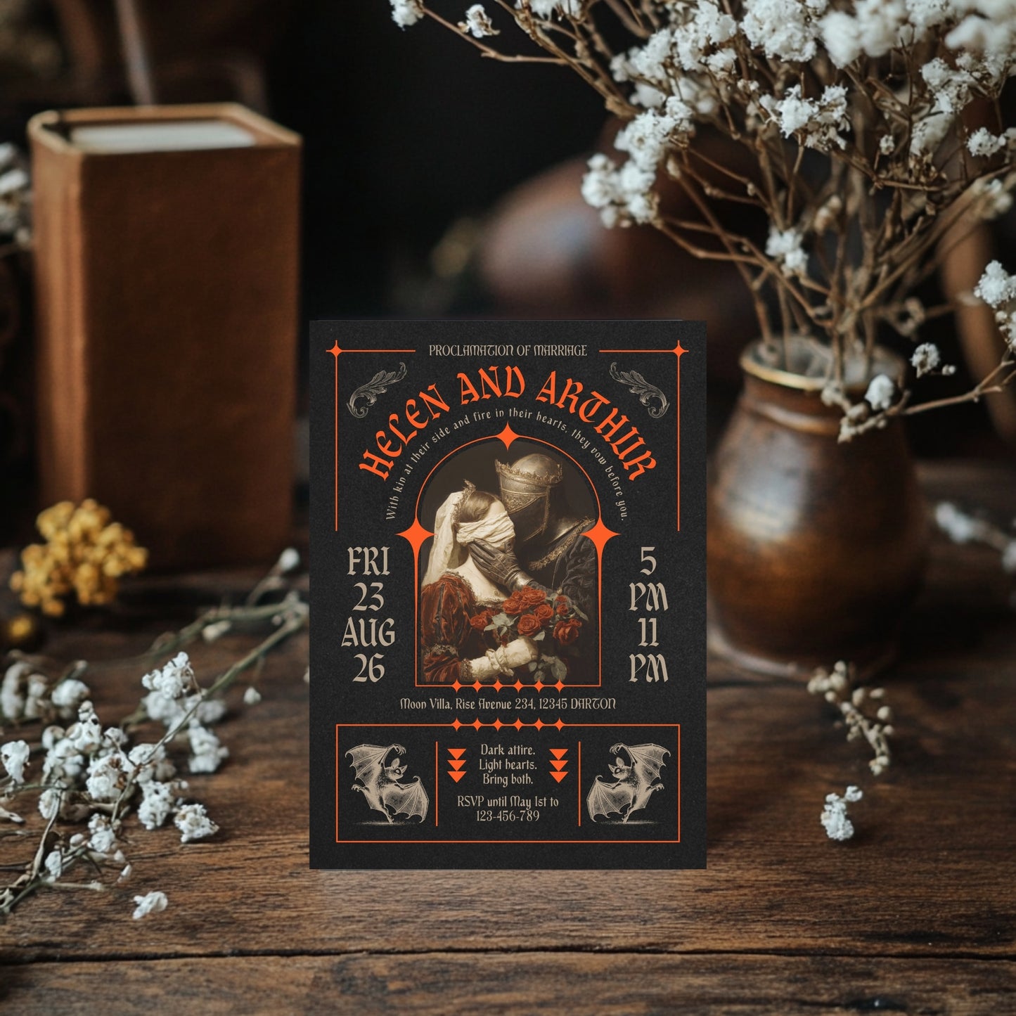 Vintage-style gothic wedding invitation with intricate brutalism design on a wooden surface with decorative elements.