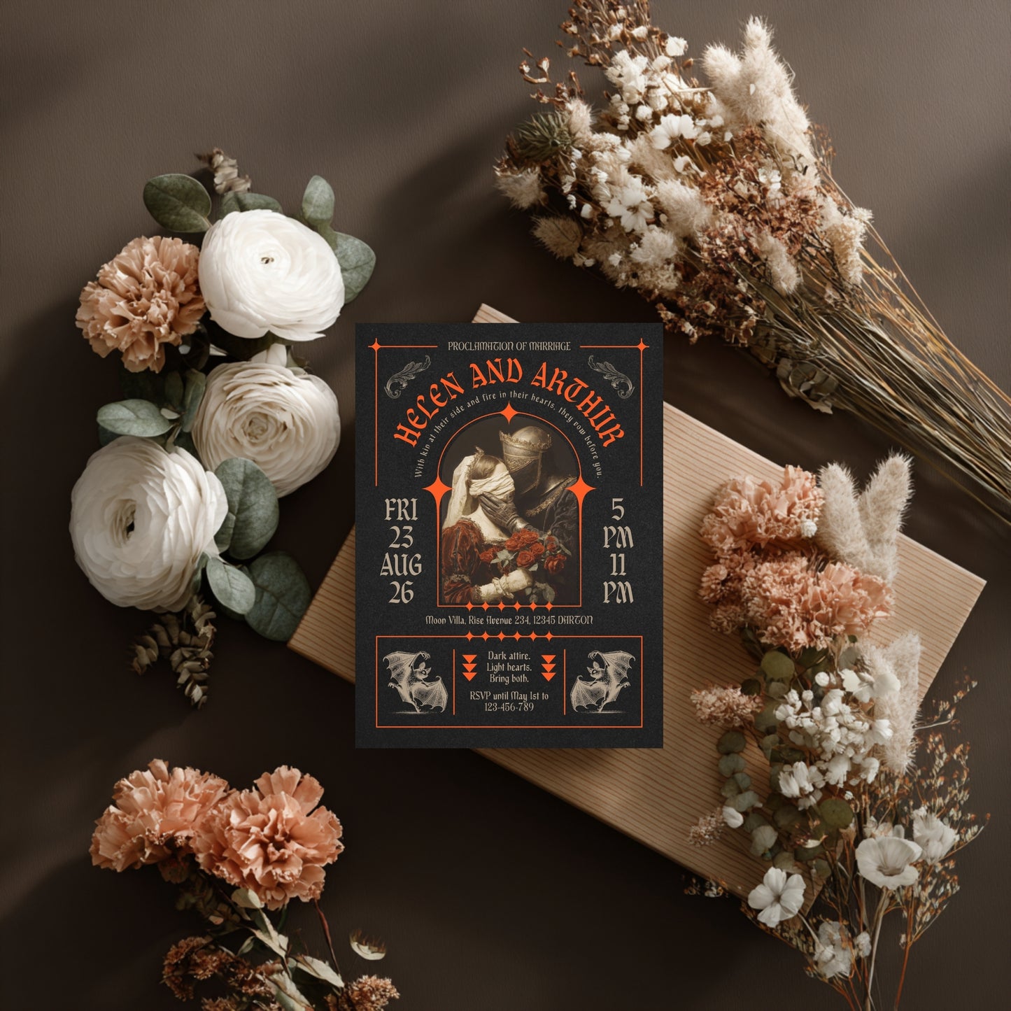 Gothic Wedding invitation card with floral decorations on a dark surface