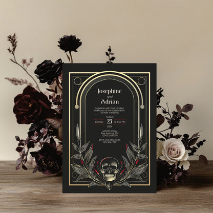 Wedding invitation card with skull design and floral arrangement on a wooden surface